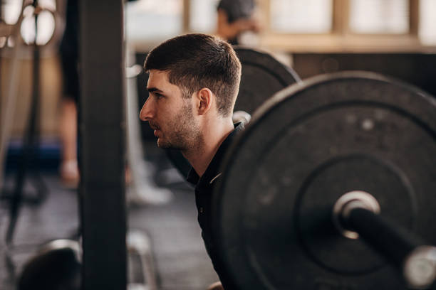 istock Muscular man exercising with weights in gym 1299283245