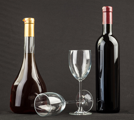Pouring red wine from a bottle into a wine glass. isolated on black background.