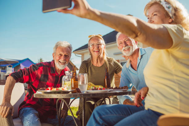 istock Senior people taking a selfie while having lunch in the backyard 1299285774