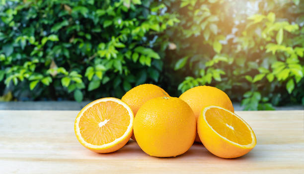 istock Close-up of front orange fruit on the table with green background at sunrise, selective focus on fresh front orange with drop water on surface oranges. Healthy drink concept 1299286602