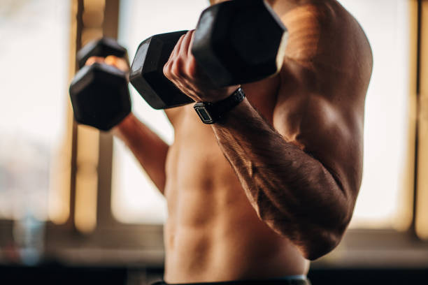 istock Muscular shirtless man exercising with dumbbells 1299287913