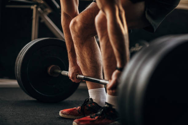 istock Man exercising with weights in gym 1299288224
