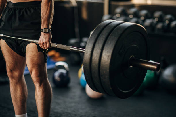 istock Muscular man exercising with weights in gym 1299288294