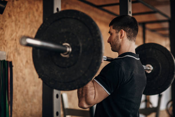 istock Muscular man exercising with weights in gym 1299288447