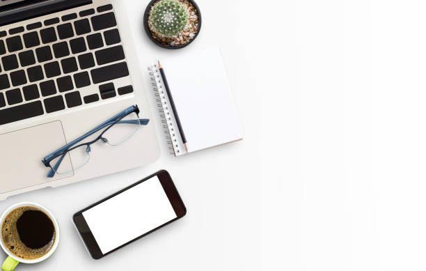 istock White office desk table with laptop computer, smart phone, notebook and eyeglasses 1299288721