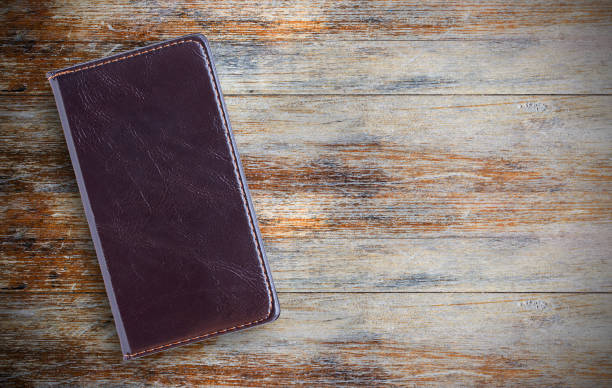 istock Blank paper notebook or notepad on brown wooden table background. 1299292436