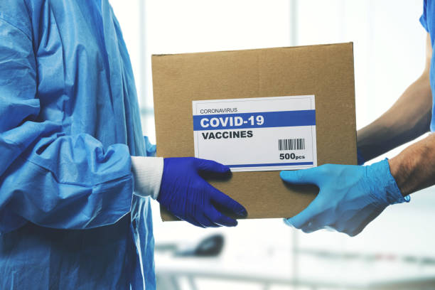 медицинский работник, принимаюющий поставку вакцин covid-19 от доставщика - product shot стоковые фото и изображения
