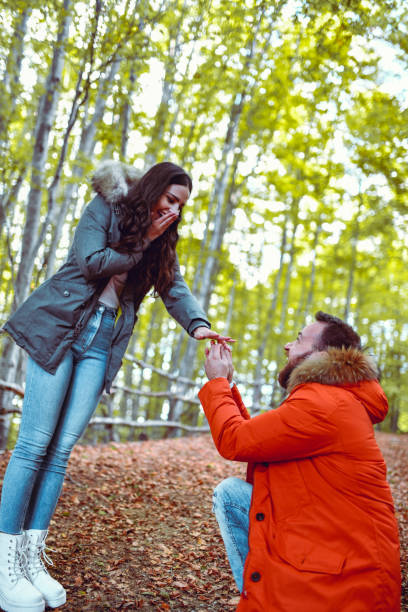istock Bearded Male Proposing to Girlfriend During Autumn Forest Vacation 1299296335