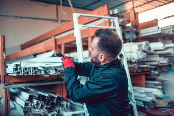 istock Male Worker Storing High Quality PVC Frames In Workshop 1299297868