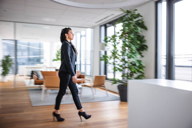 istock Well-Dressed Businesswoman Walking Through Office Lobby 1299298967