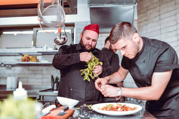 istock Modern Chefs Working On Special Dish Together In Restaurant Kitchen 1299298985