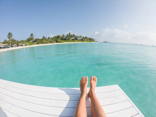 istock Woman's perspective relaxing on wooden raft above tropical lagoon 1299299614