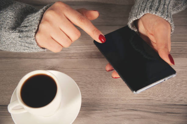 istock woman hand phone with coffee 1299305009