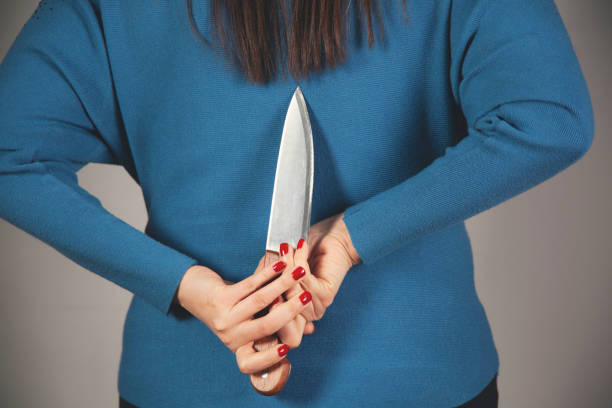 istock woman hand holding knife in back 1299305011