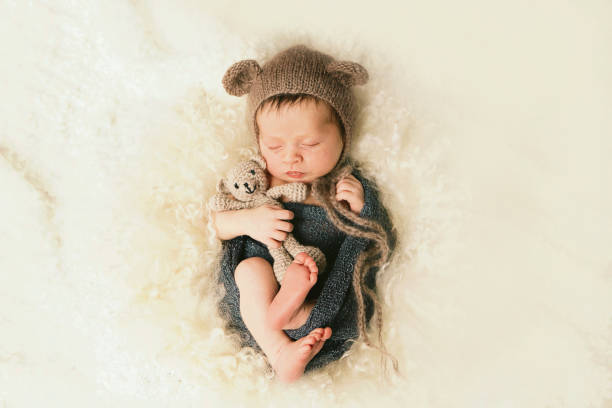 новорожденный ребенок с плюшевым медведем - baby holding babies only sign стоковые фото и изображения