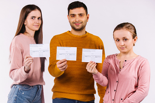 Young people with cards about vaccination against covid 19 virus. White background. High quality photo