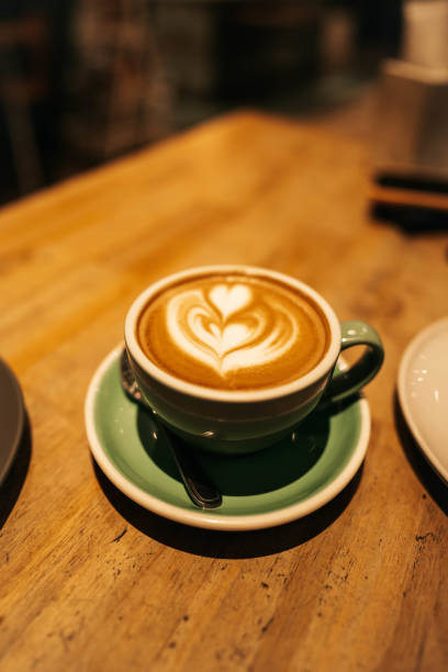 ウッド背景のグリーンセラミックカップのコーヒーラテアート - latté coffee tray froth ストックフォトと画像