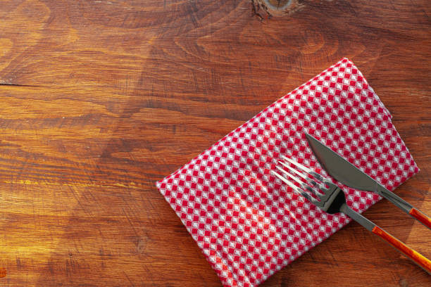 istock Red checkered napkin or tablecloth on wooden table 1299306370