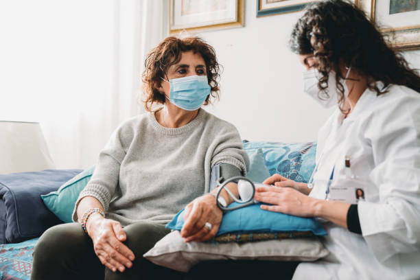 istock Doctor is visiting a patient at home, checking the patient's blood pressure 1299306696