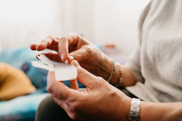 close up girato una donna matura assunzione e organizzazione di medicinali - farmaco foto e immagini stock