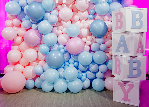 Photo zone for a gender party made of cubes and pink and blue balloons. Original to know the sex of the unborn child. boy or girl. happiness of parenthood