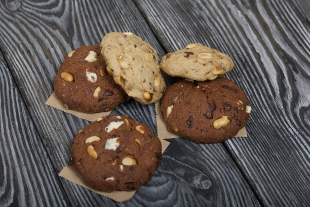 istock Oatmeal cookies with peanuts and chocolate. On pine boards. 1299308179