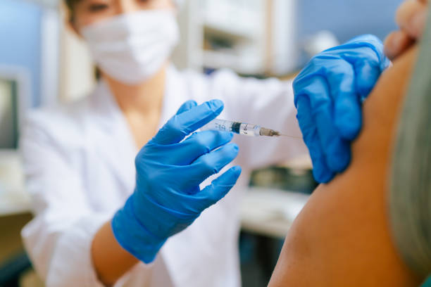 hombre adulto de la tercera edad vacunarse en el consultorio del médico - vacunación fotografías e imágenes de stock