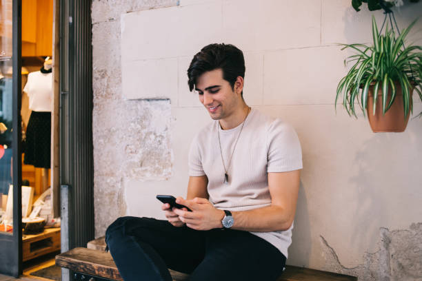 istock Young man happily messaging by mobile phone 1299309055