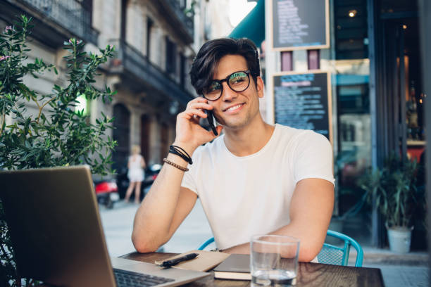istock Cheerful guy talking on smartphone in street cafe 1299309082