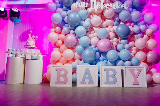 Zona de fotos para una fiesta de género hecha de cubos y globos rosas y azules photo