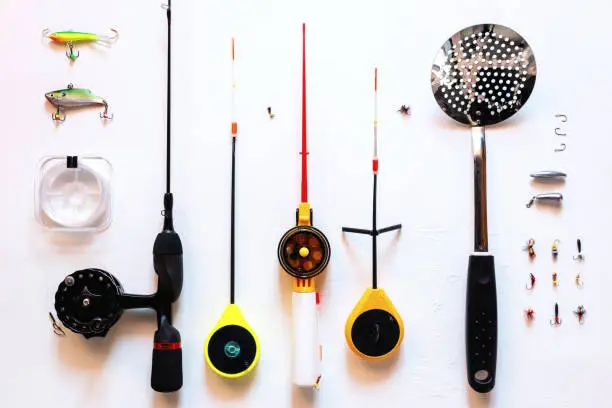 Photo of ice fishing rods, fishing line, balancers, ice jigs for winter fishing on a white foen