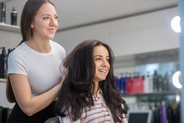 istock Female hairdresser looking involved while working with a client 1299311845