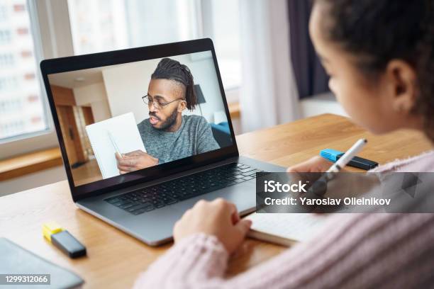 View On Laptop With Young Afro American Teacher On Laptop And A Young Student Stock Photo - Download Image Now