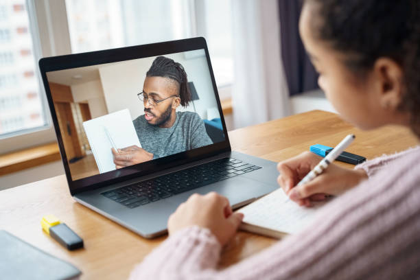 veja no laptop com jovem professor afro-americano no laptop e um jovem estudante. - professor particular - fotografias e filmes do acervo