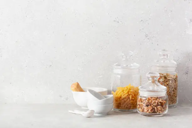 kitchen utensils on modern simple counter, kitchenware jars with dry ingredients bowls
