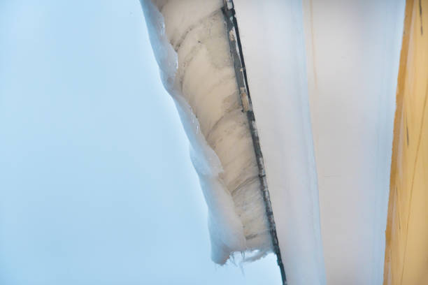lód i śnieg pokrywa budynek dachowy, niebezpieczne tamy lodowe zwisające z dachu.  koncepcja zagrożenia i bezpieczeństwa - melting ice icicle leaking zdjęcia i obrazy z banku zdjęć