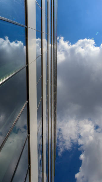 istock sky reflection in the front wall of an office building 1299313916