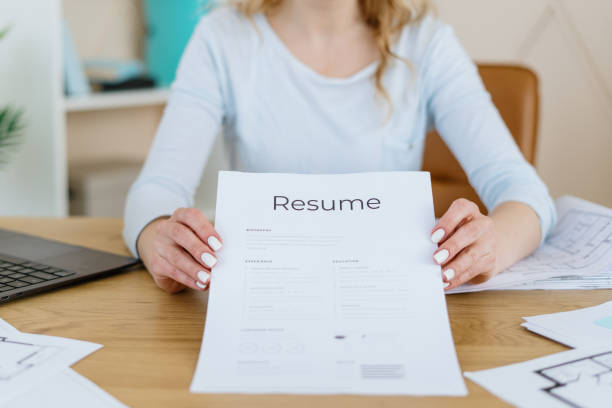 istock Recruitment manager holding cv, sitting in office 1299316189