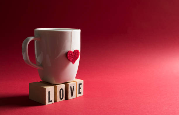 istock Cup With Heart Shape - Wooden Cubes With Love Text On Red Background 1299316742