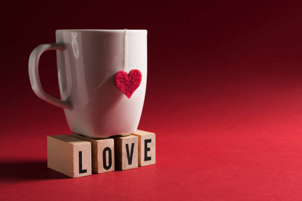 istock Cup With Heart Shape - Wooden Cubes With Love Text On Red Background 1299317796