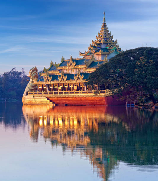 плавучий золотой дворец каравейк, выглядит как королевская баржа на закате на озере кандавгьи в янгоне, мьянма - burmese culture myanmar pagoda dusk стоковые фото и изображения