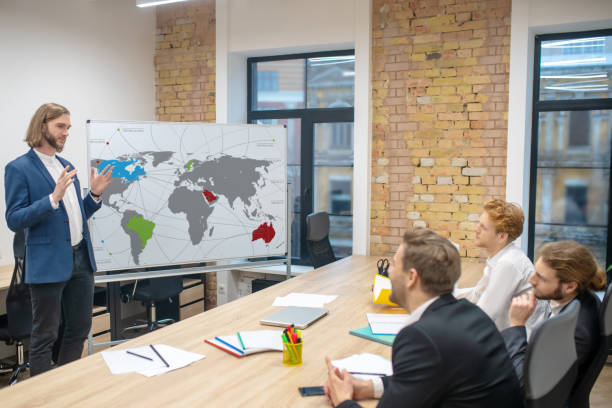 istock Man giving presentation and observing attentive colleagues 1299319776