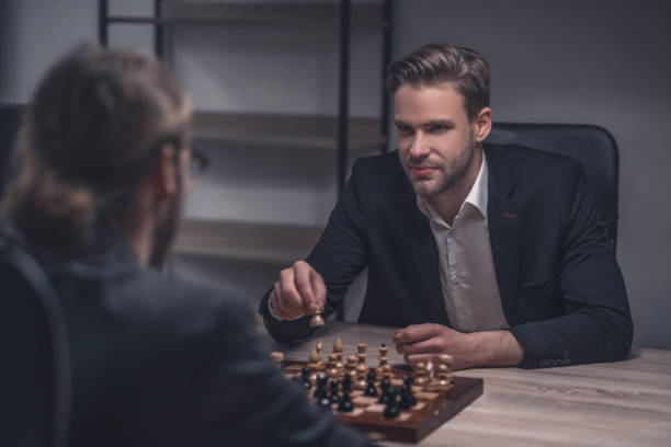 istock Smiling smart man with chess piece in hand 1299319813