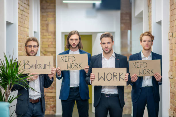 istock Four sad men with placards in their hands 1299319837