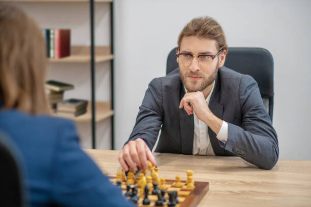 istock Man in glasses with chess piece in hand 1299319845