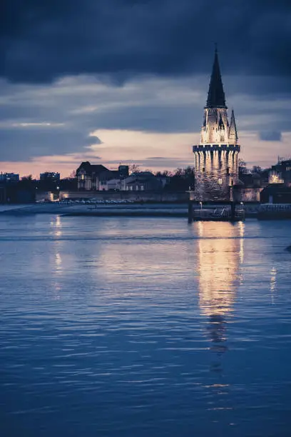 Night view of the Tour de la lanterne in La Rochelle, France. beautiful reflection in the harbor water