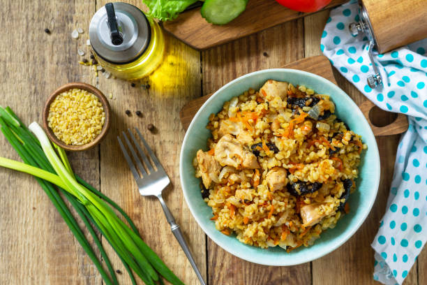 istock Bulgur with turkey and prunes is served with fresh vegetable on a rustic table. Top view flat lay. 1299323639
