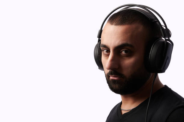 istock Young arabian man dj with headphones on isolated background 1299324256