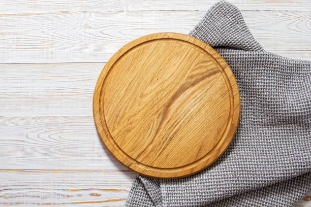 istock Pizza board with napkin on table topview. Empty pizza board top view mock up 1299324774