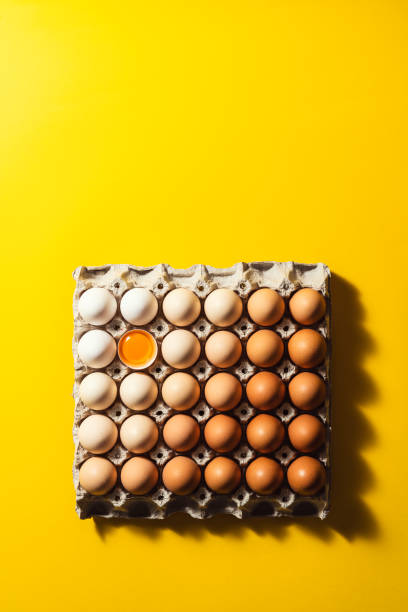 istock Box of eggs on yellow background 1299327715